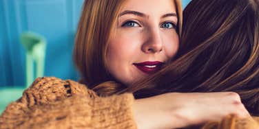 brilliant woman hugging friend avoiding boring conversation