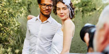 Wedding photographer taking photos of married couple