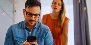 woman looking at husband cheating