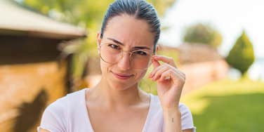 intelligent woman touching her glasses