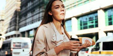 Woman eating while on her way to work.